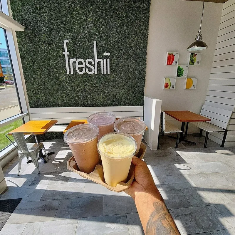 Four smoothies in a carry tray inside the Freshii Sundance dining room in Sunpark Plaza